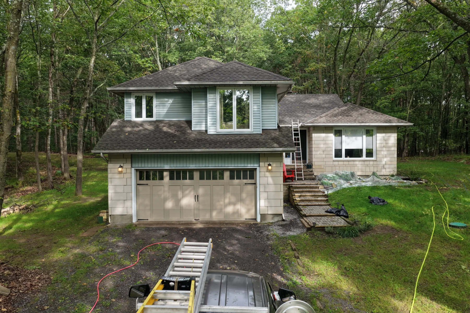Aerial view of a residential exterior surrounded by woodland.